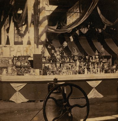 Half-view Stereograph of Table with Various Pieces of Merchandise by J.A. Scholten